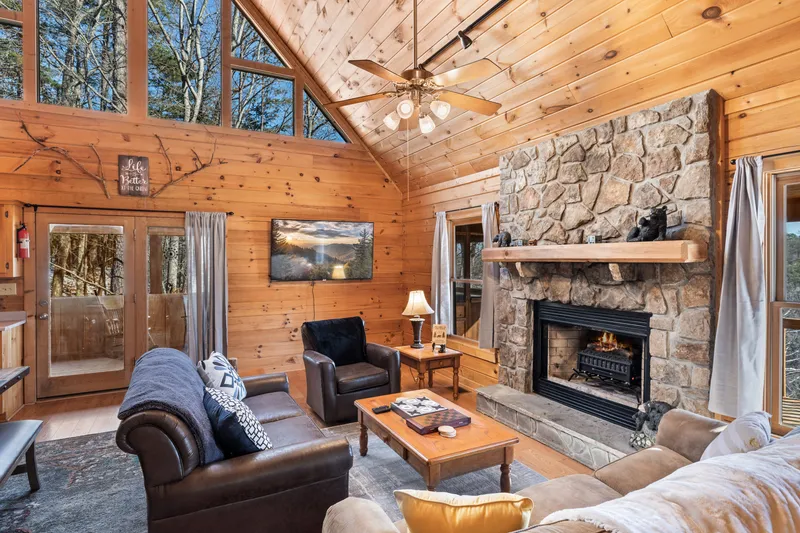 Cabin living room with stone fireplace lit, a cozy rainy day indoors near Gatlinburg