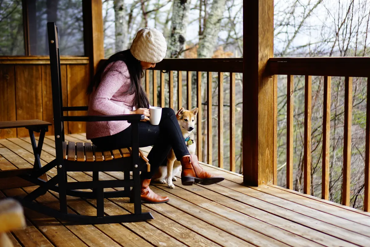Ariana with morning coffee and our dog in the porch rocking chairs